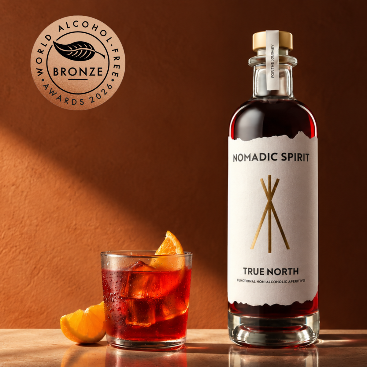 A bottle of True North beside a bittersweet aperitivo served over ice with orange, carrying the World Alcohol-Free Awards 2026 bronze medal