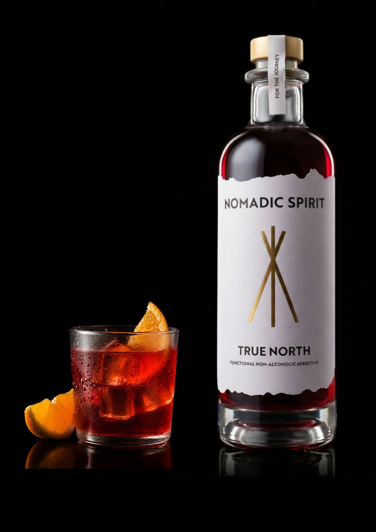 A bottle of True North beside a served drink with orange, shot on black